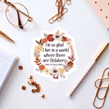 a sticker with a quote, surrounded by various office supplies such as pens, a notebook, and a pair of glasses.