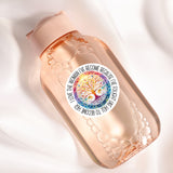 A pink bottle with a label featuring a tree design and text.