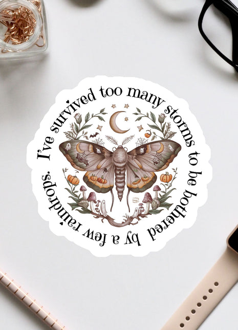 a sticker with a butterfly design, surrounded by various office supplies and accessories such as a pair of glasses, a pen, and a watch.