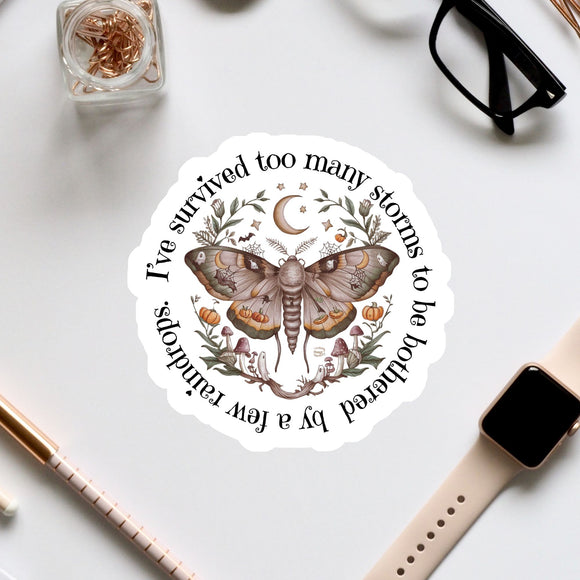 a sticker with a butterfly design, surrounded by various office supplies and accessories such as a pair of glasses, a pen, and a watch.