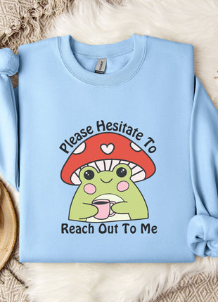 A light blue sweatshirt with a mushroom graphic and text, along with a mug and some white flowers, all laid out on a white fur rug.