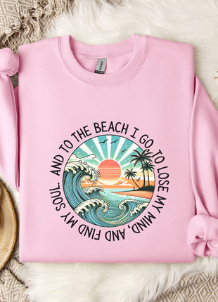 A pink sweatshirt with a graphic design depicting a beach scene, along with the text "And to the beach I go, I lose my soul, I lose my mind".