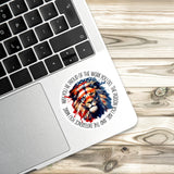 A sticker with an image of a lion is placed on the edge of a laptop keyboard.
