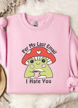 A pink sweatshirt with a cartoon frog wearing a red mushroom hat and holding a cup, accompanied by a mug, a branch of cotton bolls, and a text that says "Per My Last Email I Hate You".