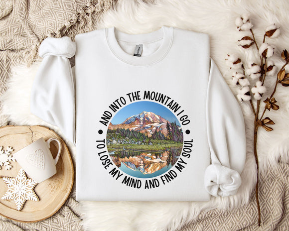 A white sweatshirt with a mountain landscape design and the text 