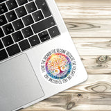 A sticker with a colorful tree design is placed on the edge of a laptop keyboard.