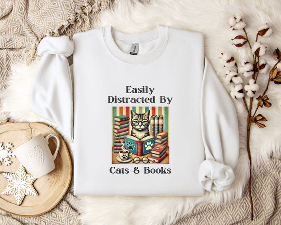 A white t-shirt with a graphic design of a cat surrounded by books, along with the text 