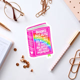a sticker with a book and a quote, surrounded by various office supplies such as pens, a notebook, and a pair of glasses.