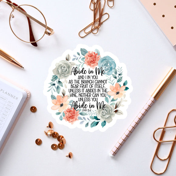 a sticker with a floral design, surrounded by various office supplies such as pens, a notebook, and a pair of glasses.