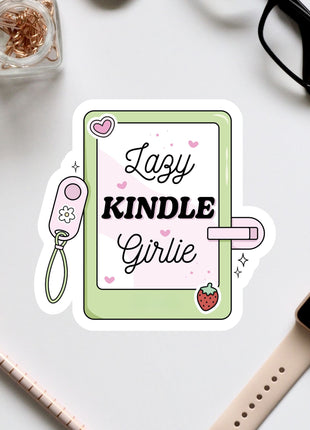 a sticker with the text "Lazy KINDLE Girlie" surrounded by various objects such as a pair of glasses, a watch, and a pen.