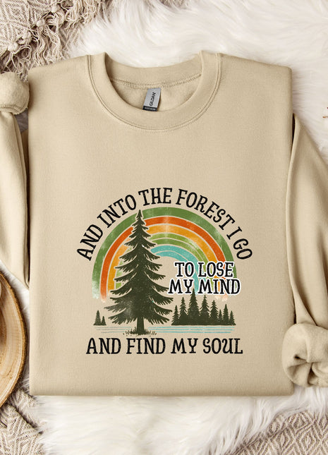 A beige sweatshirt with a graphic design of a forest and a rainbow, along with the text "AND INTO THE FOREST I GO TO LOSE MY MIND AND FIND MY SOUL".