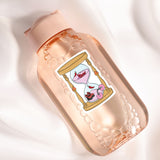 A pink bottle with a label featuring a cartoon illustration of a sand timer with a pink flower inside.
