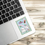A sticker with a space-themed illustration is placed on the edge of a laptop keyboard.