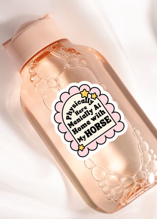 A pink bottle with a label that says "Physically Here Manually At Home With My Horse"