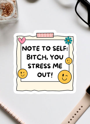 a sticker with a humorous message, surrounded by various office supplies and a pair of glasses on a white surface.