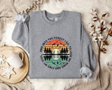 A gray sweatshirt with a graphic design depicting a sunset over a forest, along with the text "And into the forest I go, to lose my mind and find my soul".
