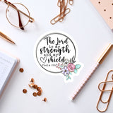 a sticker with a quote from the Bible verse Psalm 28:7, surrounded by various office supplies such as pens, a notebook, and a pair of glasses.