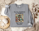 a gray sweatshirt with a graphic design of a raccoon surrounded by books, along with text that reads "I'm Not Qualified To Diagnose But I Have Theories".