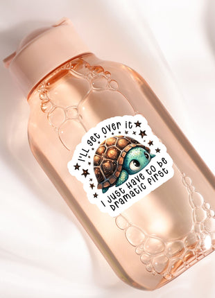 A pink bottle with a sticker featuring a cartoon turtle and the text "I'll see over it, I just have to be dramatic first".