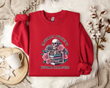 A red sweater with a skull and floral design, along with a mug and some white flowers, is displayed on a white fur rug.