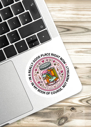 A sticker with a cartoon image of a jar of pickles and the text "In a really good place right now, not mentally ill" is placed on a laptop keyboard.