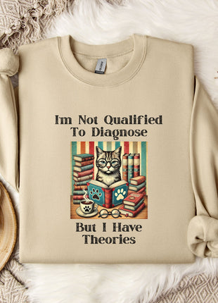 a beige sweatshirt with a humorous text and an illustration of a cat surrounded by books, placed on a bed with a white blanket and a mug.