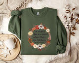 A green sweatshirt with a floral design and text printed on it, placed on a white fur rug.