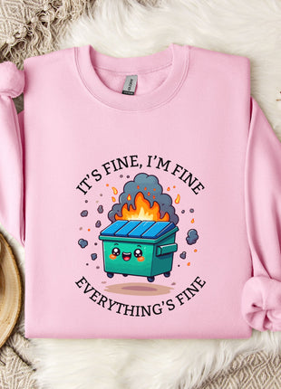 A pink sweatshirt with a graphic design depicting a fire-breathing trash can, accompanied by the text "It's fine, I'm fine Everything's fine".
