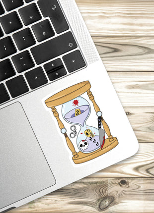 a sticker with an illustration of a sand timer on a laptop keyboard.